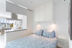 a white bedroom with a bed and a kitchen at Brisas Canarias in Puerto Rico de Gran Canaria +15 photos