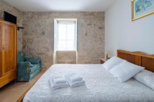 a bedroom with a bed with two towels on it at Casa De Marica in A Estrada +26 photos