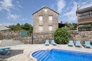 a house with a swimming pool in front of a building at Casa De Marica in A Estrada