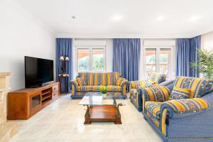 a living room with couches and a flat screen tv at Villa Epi in Cala Ratjada