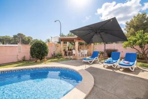a swimming pool with two chairs and an umbrella at Villa Epi in Cala Ratjada