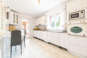 a white kitchen with white cabinets and a table at Villa Epi in Cala Ratjada