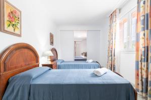 a bedroom with two beds with blue sheets at Villa Epi in Cala Ratjada +23 photos