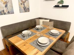 a wooden table with plates and wine glasses on it at Gemütliche Ferienwohnung in Drolshagen +15 photos