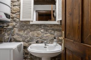 a bathroom with a sink and a stone wall at Casa Rural Adrimar in Selorio +36 photos