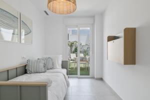 a white room with a bed and a table at La Casa de Emilie- Solo Familias in Conil de la Frontera +19 photos