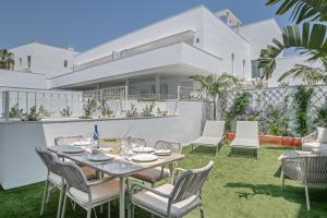 a patio with a table and chairs in front of a house at La Casa de Emilie- Solo Familias in Conil de la Frontera