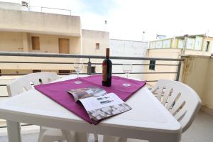 a white table with a bottle of wine and two glasses at Casa Vacanze Marta in Otranto