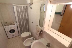 a bathroom with a toilet sink and a washing machine at Casa Vacanze Marta in Otranto