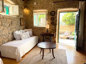 a living room with a couch and a table at Traditional Stone House in Lazaráta