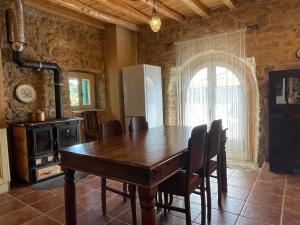 a dining room with a wooden table and a stove at Traditional Stone House in Lazaráta +37 photos