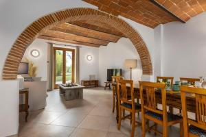a dining room with an archway and a table and chairs at Villa Arnolfo in Colle di Val d'Elsa