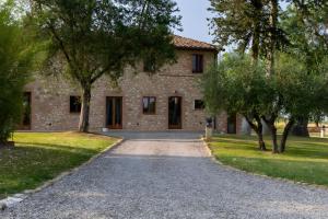 a stone house with a driveway in front of it at Villa Arnolfo in Colle di Val d'Elsa