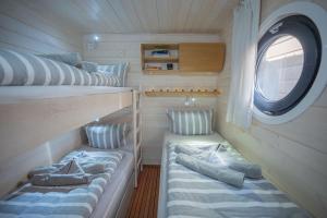 a small room with two bunk beds and a window at Magisches Abenteuer-Hausboot Juno in Fürstenberg
