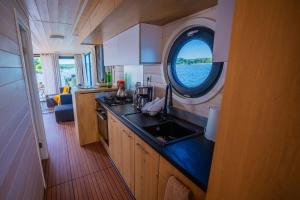 a kitchen with a sink and a round window at Magisches Abenteuer-Hausboot Juno in Fürstenberg