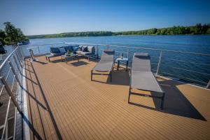 a group of chairs and tables on the deck of a boat at Magisches Abenteuer-Hausboot Juno in Fürstenberg
