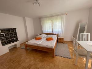 a bedroom with a bed with orange pillows on it at Haus Linsendorf in Gallizien