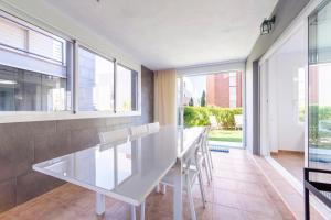 a white table and chairs in a room with windows at Apartamento Luz De Baria in Vera