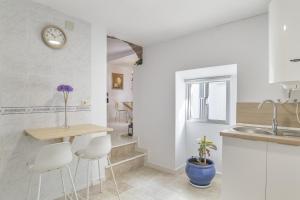 a kitchen with white walls and a table and chairs at El Rincón de Hugo in Alcalá de los Gazules