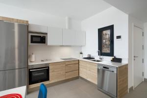 a kitchen with white cabinets and stainless steel appliances at Yucas Villa 13 in San Bartolomé