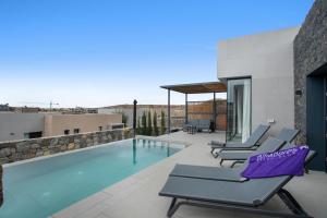 a swimming pool with lounge chairs next to a building at Yucas Villa 13 in San Bartolomé