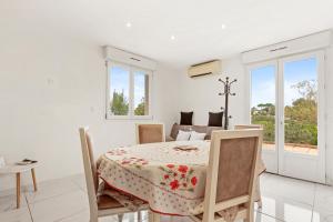 a white dining room with a table and chairs at Charmant appartement avec terrasse in Brignoles +12 photos