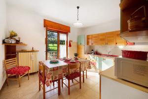 a kitchen with a table and some chairs and a microwave at Maison Lorent in Champdepraz