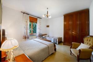 a bedroom with a bed and a chair and a window at Maison Lorent in Champdepraz