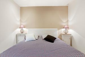 a bedroom with a bed with two lamps on two sides at Charmant appartement avec terrasse in Brignoles