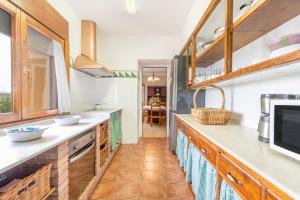a kitchen with white counter tops and wooden cabinets at Ca l'Andorrà in Vila-Sana