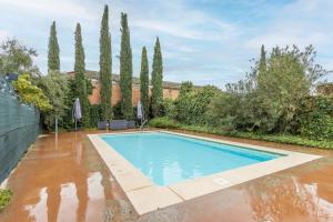 a swimming pool surrounded by water in a yard with trees at Ca l'Andorrà in Vila-Sana
