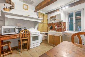a kitchen with a table and a microwave at Véritable Mas Provençal À La Palud in La Palud-sur-Verdon +14 photos