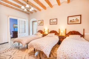 a bedroom with three beds in a room at Ca l'Andorrà in Vila-Sana +29 photos