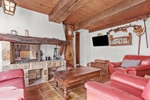 a living room with a stone fireplace and red furniture at Véritable Mas Provençal À La Palud in La Palud-sur-Verdon