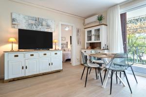 a living room with a table with chairs and a television at beach and pool in Cambrils