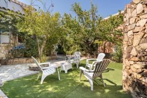 a group of white chairs and tables in a yard at Al mare da Pépé in Budoni