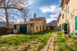 an alley in an old house with mountains in the background at Véritable Mas Provençal À La Palud in La Palud-sur-Verdon