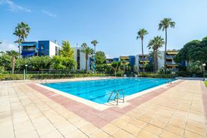 a swimming pool at a resort with palm trees and buildings at beach and pool in Cambrils