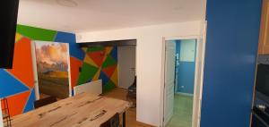 a room with a table and a colorful wall at Appartement La Perle Du Sancy in La Bourboule +2 photos
