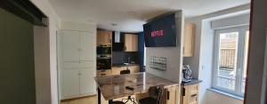 a kitchen with white cabinets and a sign that readsfaith at Appartement La Perle Du Sancy in La Bourboule