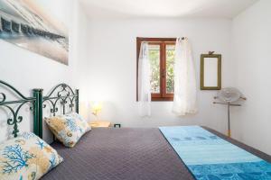 a bedroom with a bed and a window at Al mare da Pépé in Budoni