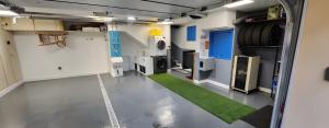 an empty garage with a green carpet in the middle at Appartement La Perle Du Sancy in La Bourboule