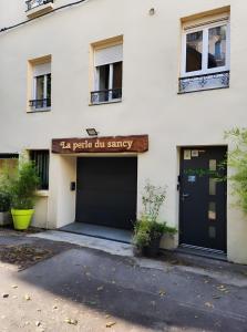 a white building with a garage with a sign on it at Appartement La Perle Du Sancy in La Bourboule