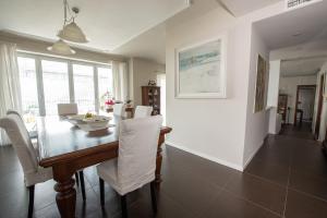a dining room with a table and white chairs at Stanza in Villa Magica in Credaro