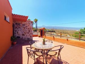 a patio with a table and chairs on a balcony at Villa María in Taco