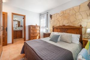 a bedroom with a large bed with a stone wall at Villa María in Taco