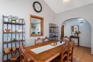 a dining room with a table and a clock on the wall at Villa María in Taco