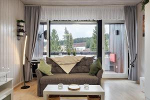 a living room with a couch and a large window at Quality Time auf 1000 Meter in Schönwald