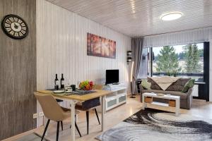 a living room with a desk with a computer and a couch at Quality Time auf 1000 Meter in Schönwald