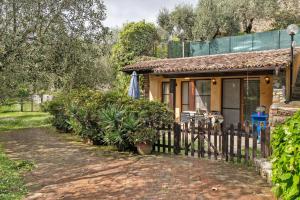 a house with a fence in front of it at Il Giardino del Sole, Chalet Salvia in Garlenda